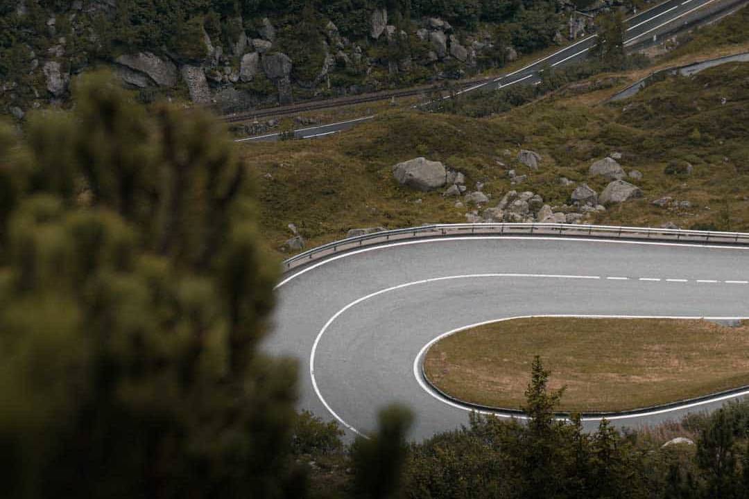 Scenic winding road through lush green mountain landscape, ideal for challenging road cycling tours and picturesque rides.