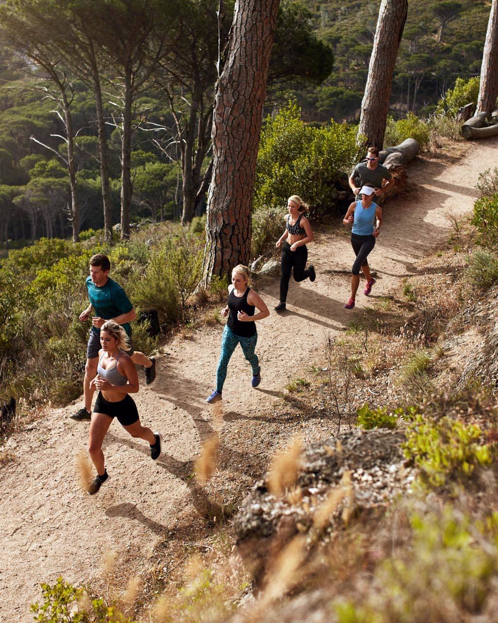 Group of runners in a cross country race. Young people running in nature. Trail running workout.
