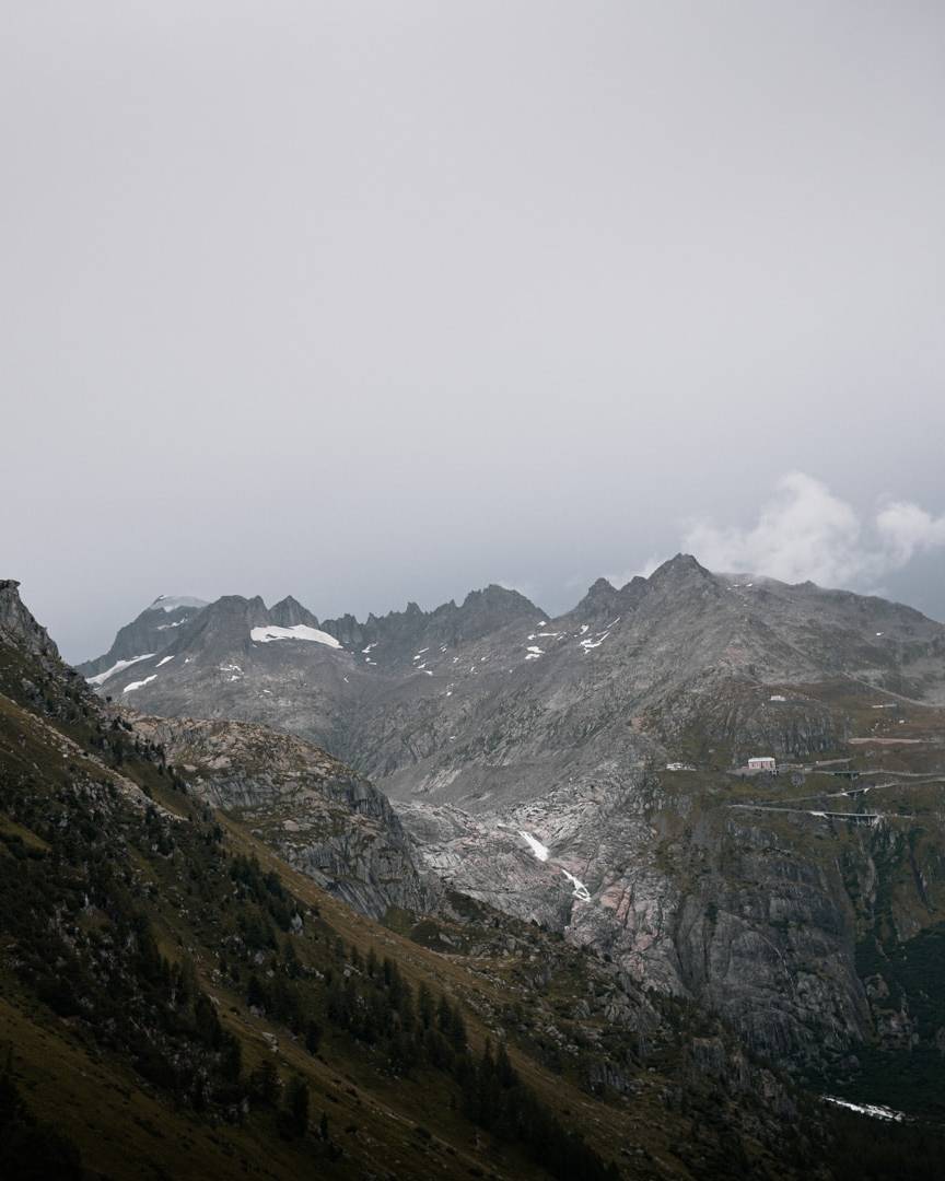 A stunning mountain landscape with winding roads and rugged peaks, ideal for discovering a challenging and scenic road cycling route through the highlands.