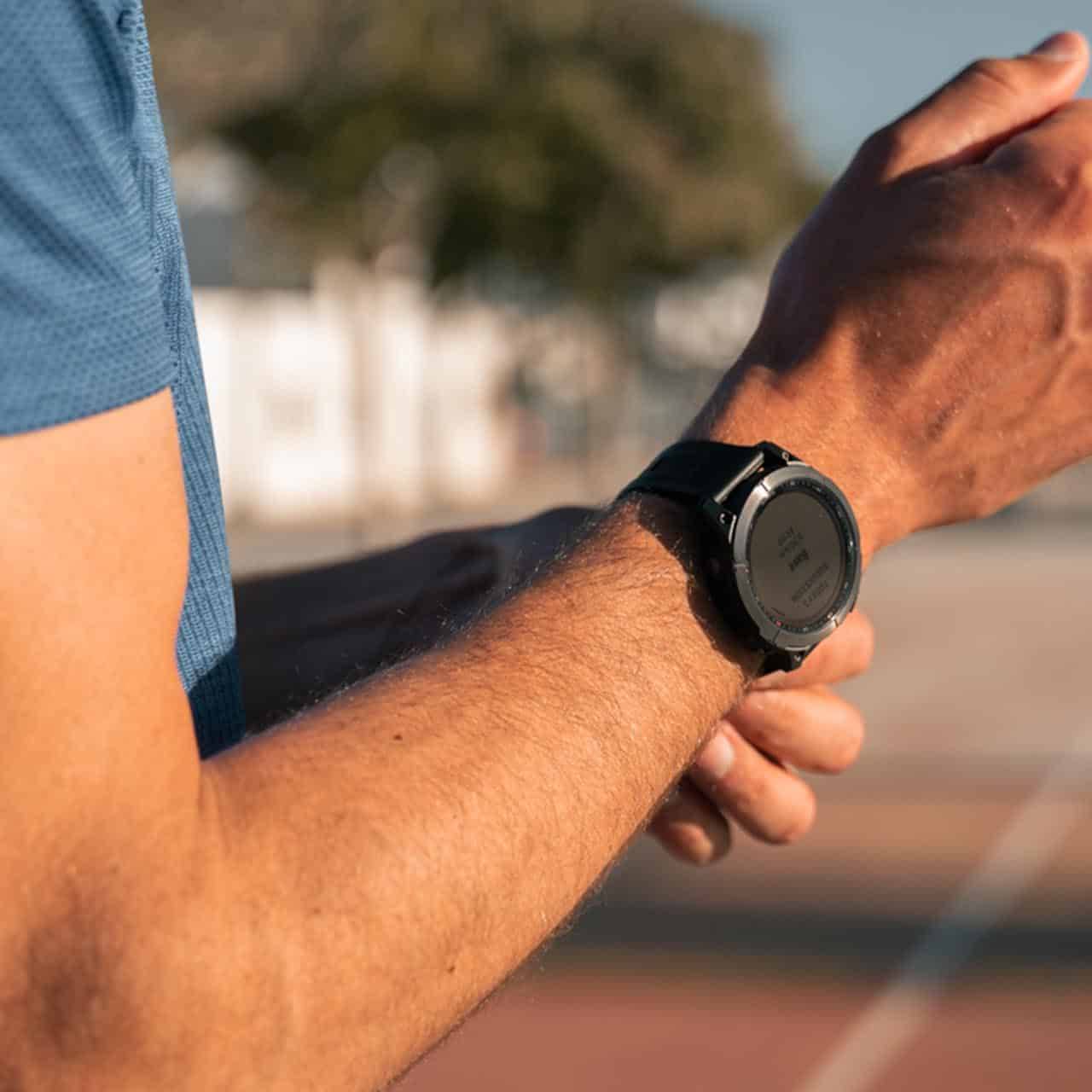 Close-up of a man adjusting his Garmin smartwatch before a workout.