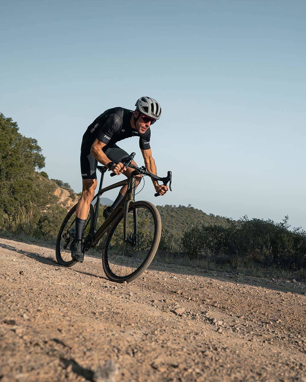 Cyclist tackling a rugged gravel path under a clear sky, showcasing thrilling gravel cycling experiences in Europe’s top destinations.